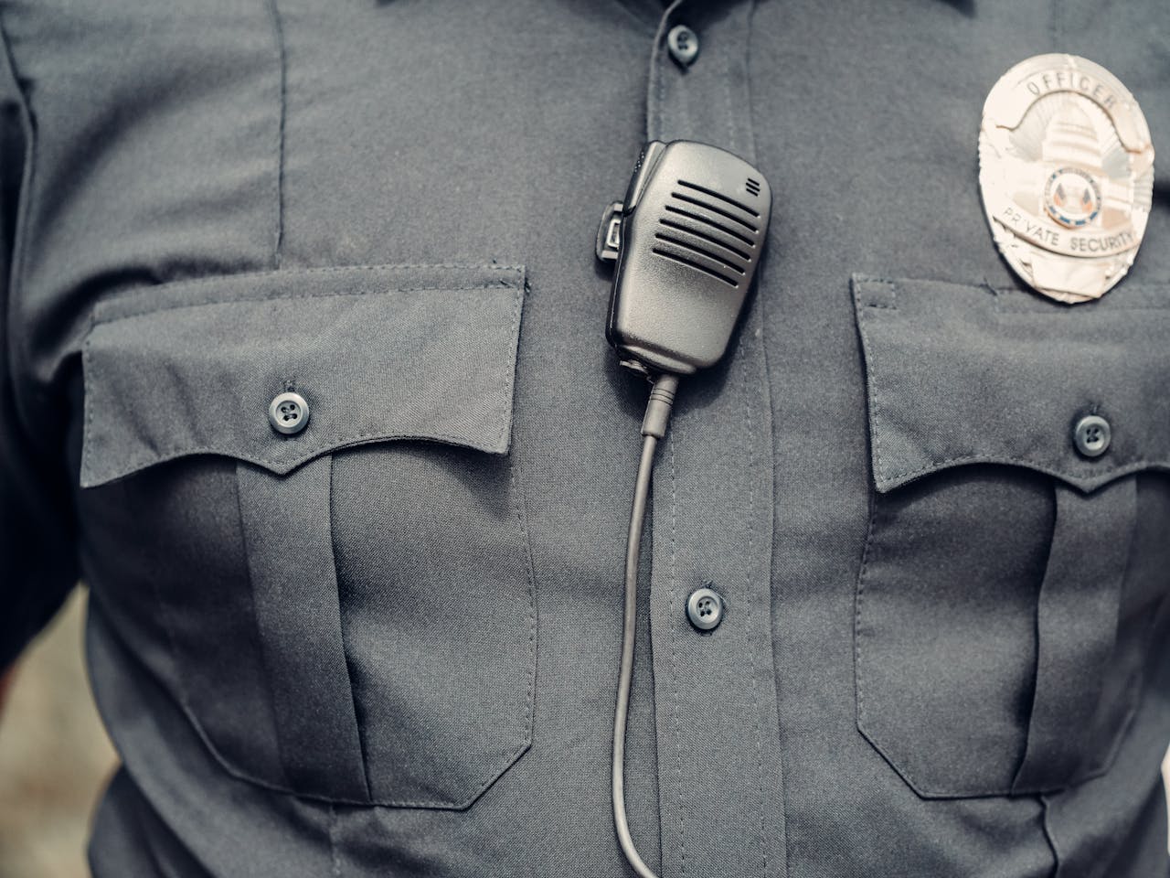 Close-up of a police officer's uniform featuring a body camera and badge.